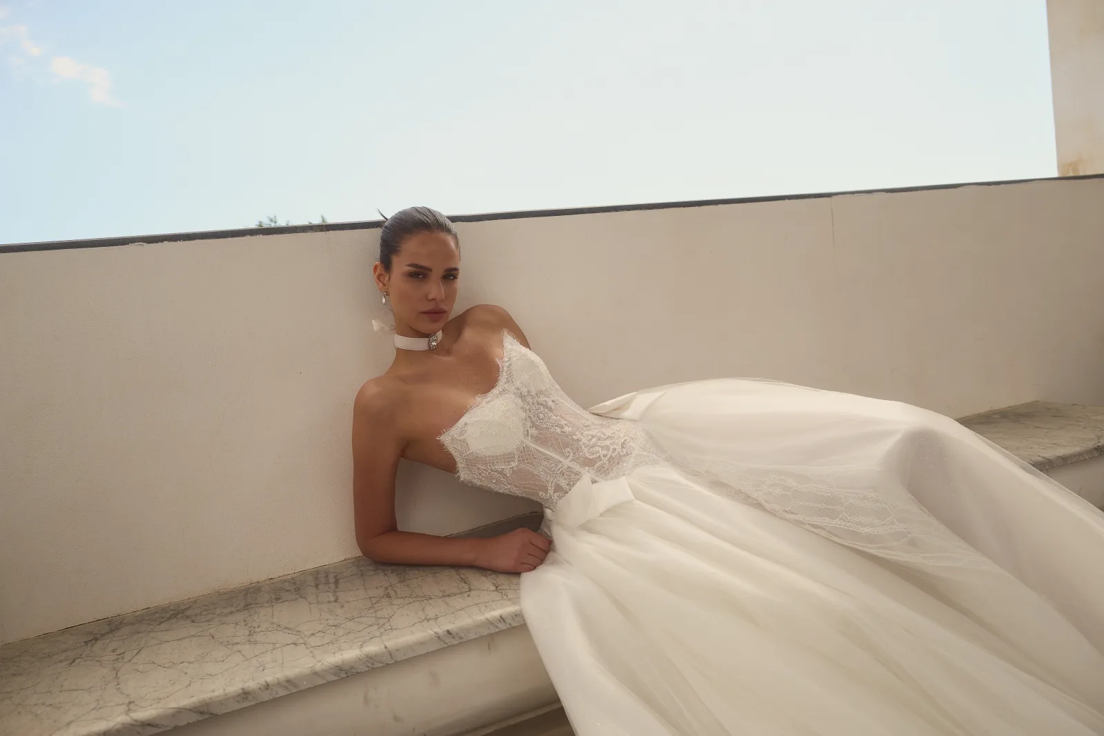 Dettaglio del corsetto in pizzo e dei fiocchi couture dell’abito da sposa Cambridge