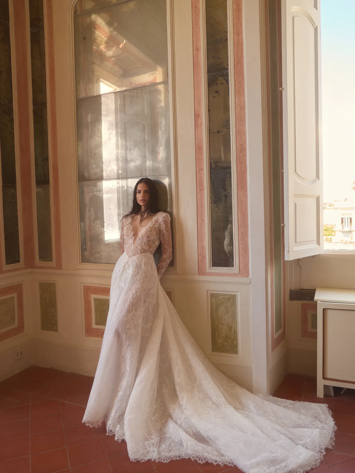 Dettaglio dello scollo profondo incorniciato dal pizzo dell’abito da sposa Interdit